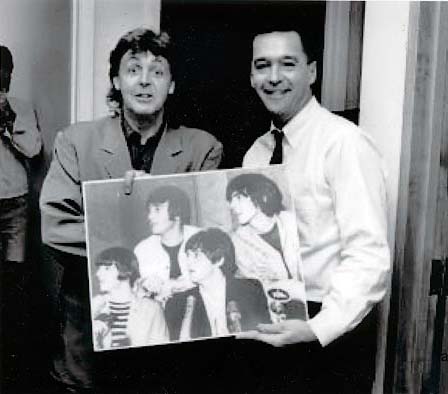 Paul McCartney holding a print of a rare photo by John Rowlands